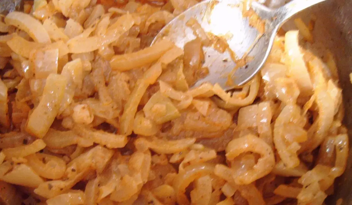 Smażona cebula z przyprawami, wygląda jak pyszna omasta do pierogów.