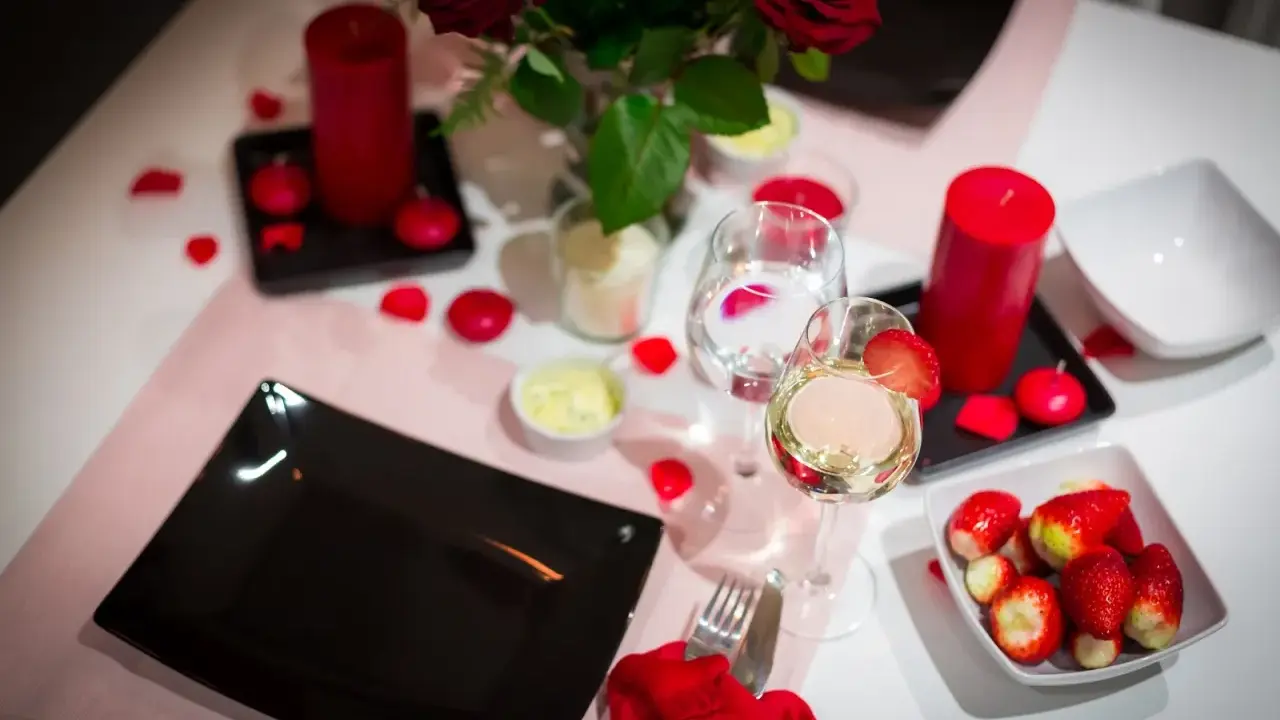 Romantyczna kolacja walentynkowa: czerwone róże, świece, wino i truskawki. Idealne inspiracje, co ugotować na walentynki.