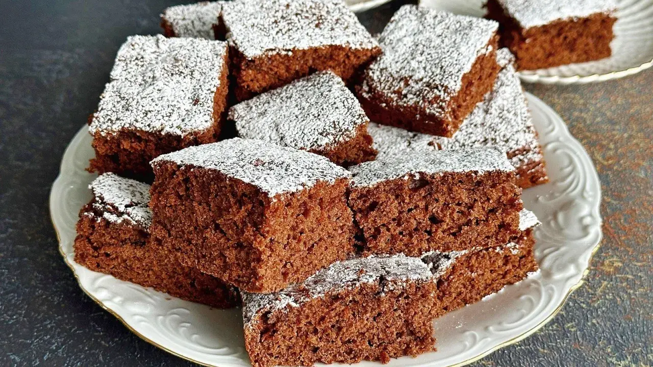 Pyszne, wilgotne ciasto czekoladowe pokrojone w kostkę, posypane cukrem pudrem. Idealne na przepis na ciasto kręcone.