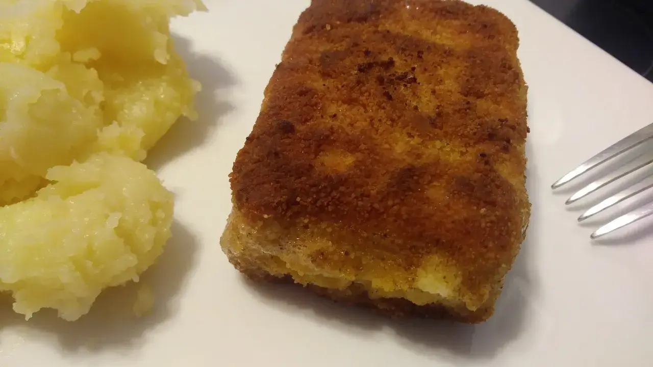 Złociste, chrupiące kostki rybne mrożone w panierce, idealne do szybkiego obiadu. Podane z purée ziemniaczanym.