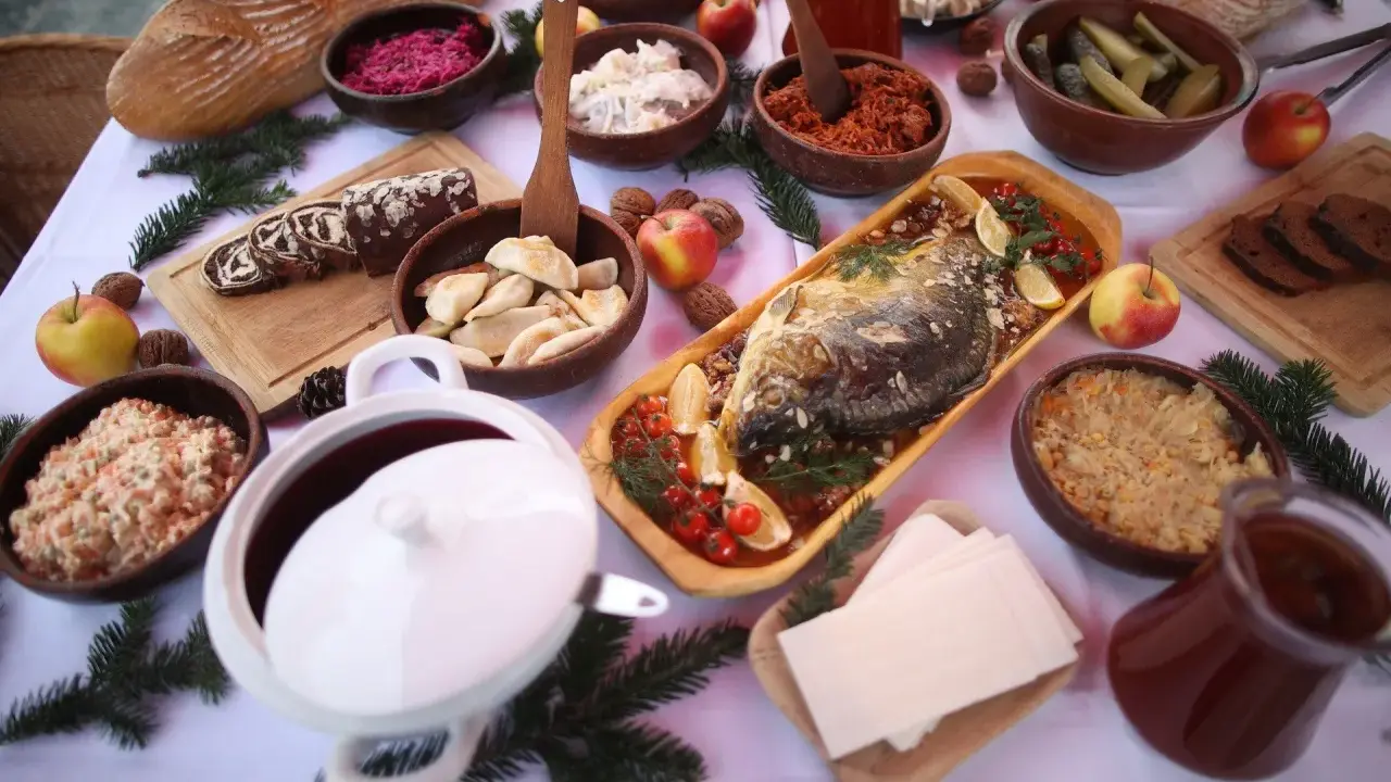Wigilijny stół pełen smakołyków: karp, pierogi, kapusta, barszcz i chleb. Idealne inspiracje, co ugotować na Wigilię.
