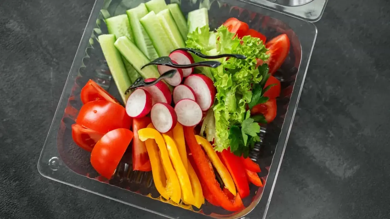 Świeże warzywa w pudełku – idealne na start, gdy zastanawiasz się, jak otworzyć catering dietetyczny. Pomidory, ogórki, rzodkiewki, papryka i sałata.