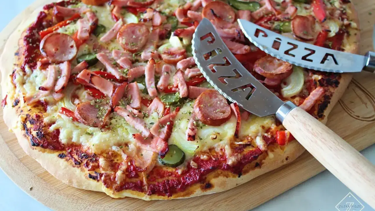 Pyszna pizza z kiełbasą i warzywami, gotowa do pokrojenia. To najlepsza pizza przepis, jaki kiedykolwiek próbowałeś!