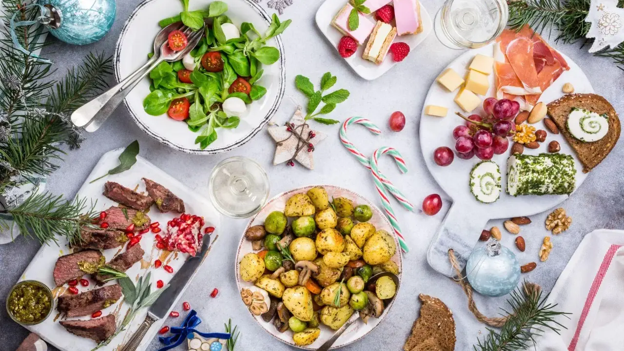 Wigilia na talerzu: pieczone ziemniaki, mięso, sałatka, ser, słodkości. Zastanawiasz się, ile kosztuje catering na wigilię?