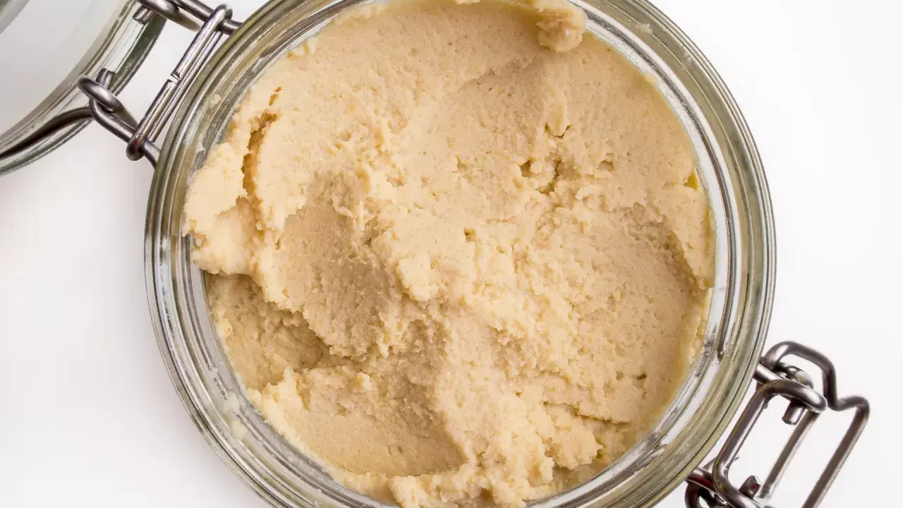 Słoik z domowym hummusem. Zastanawiasz się, czy można mrozić hummus? Tak, można go zamrozić, by dłużej zachował świeżość.