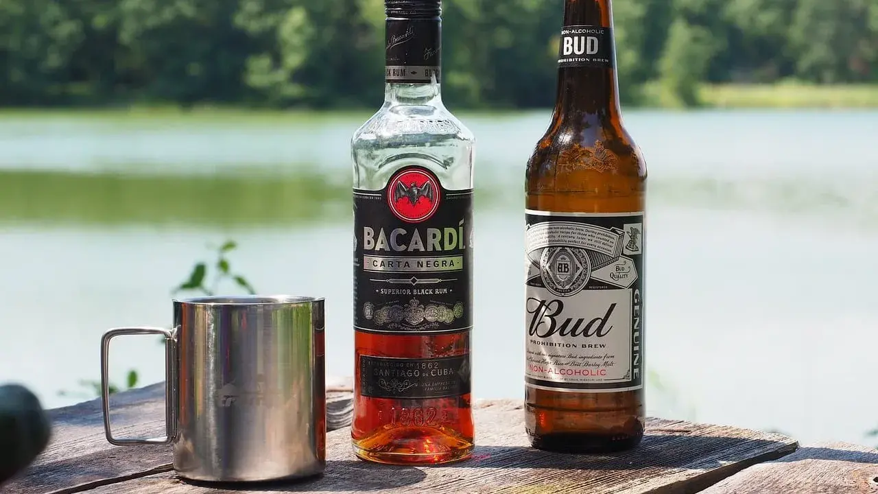 Bacardi Carta Negra i piwo Bud na drewnianym stole. Zastanawiasz się, jaki alkohol do tiramisu? Rum Bacardi to świetny wybór!