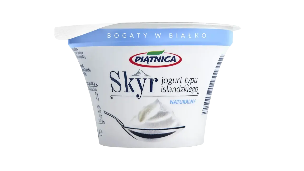 Opakowanie jogurtu typu islandzkiego Skyr Piątnica Naturalny z łyżką pełną jogurtu.