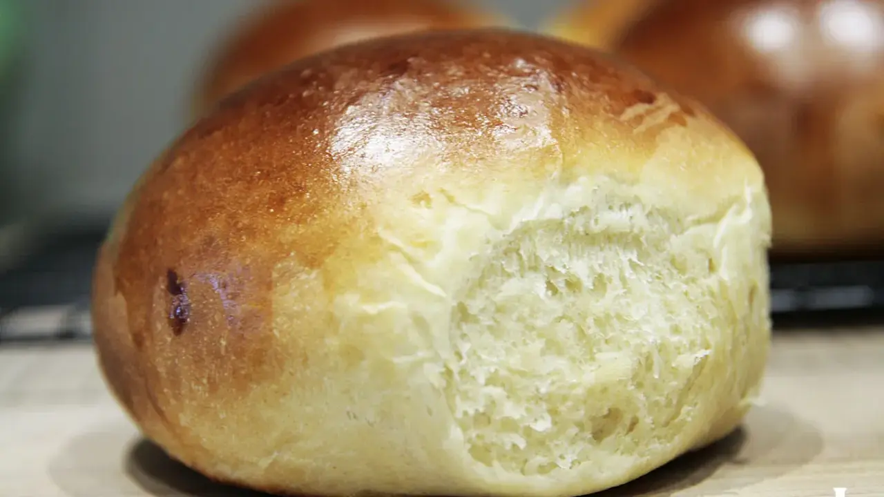 Złociste bułeczki brioche z widocznym, puszystym wnętrzem.