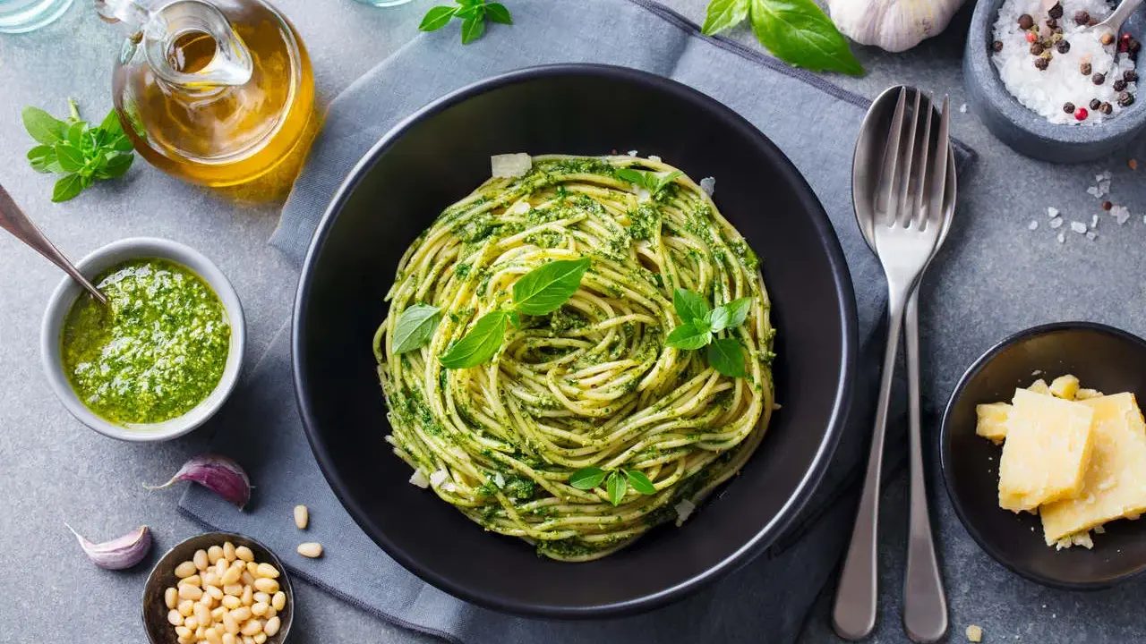 Pyszne spaghetti z pesto to idealna odpowiedź na pytanie: co zrobić na obiad bezmięsny. Podane z parmezanem i świeżą bazylią.