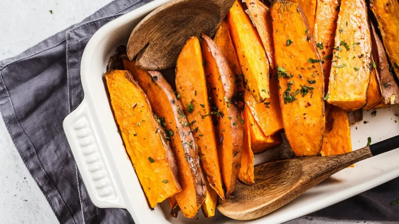 Pieczone bataty w naczyniu, posypane ziołami. Idealne, by pomyśleć co do batatów na obiad.