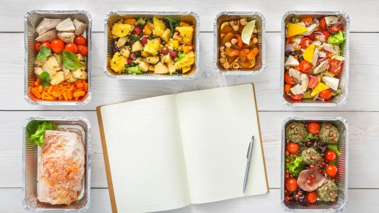 Planujesz catering dietetyczny? Warto! Sześć pudełek z pysznym jedzeniem i notatnik do zapisania celów.