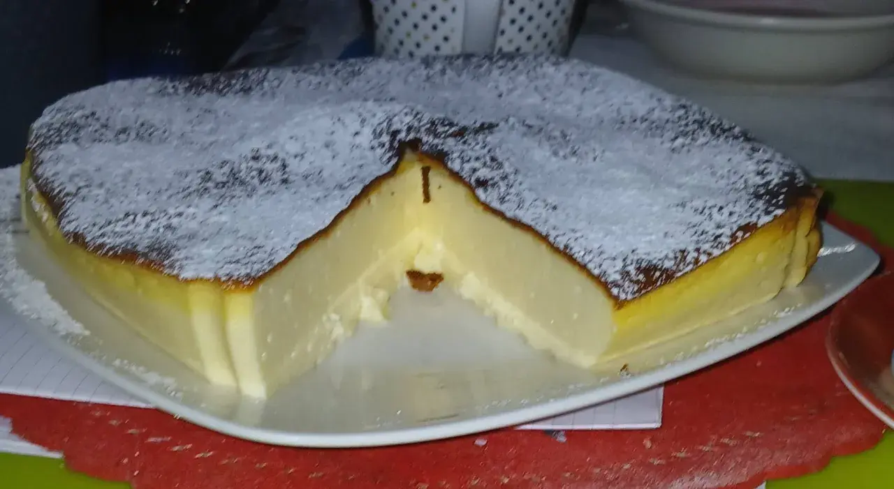 Puszysty sernik z airfryer, oprószony cukrem pudrem, z lekko przypieczoną skórką i kremowym wnętrzem.