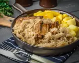 Pyszne żeberka w kapuście kiszonej, idealne do pieczenia w piekarniku. Podane z ziemniakami.