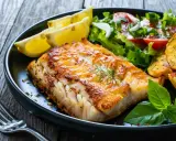 Idealny wybór, co do ryby na obiad: soczysty filet rybny z chrupiącymi ziemniaczkami, świeżą sałatką i cytryną.