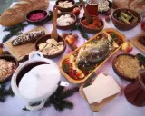 Wigilijny stół pełen smakołyków: karp, pierogi, kapusta, barszcz i chleb. Idealne inspiracje, co ugotować na Wigilię.