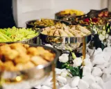 Bufet z jedzeniem: naleśniki, sałatka, smażone kąski. Zastanawiasz się, ile kosztuje catering na imprezę?