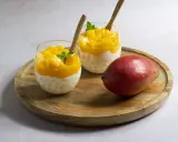 Pyszny deser z tapioki i mango, idealny sposób, by wykorzystać mrożone mango. Podany w szklankach z drewnianymi łyżeczkami.