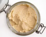 Słoik z domowym hummusem. Zastanawiasz się, czy można mrozić hummus? Tak, można go zamrozić, by dłużej zachował świeżość.