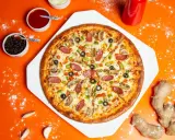 Chrupiąca pizza z pieczarkami, salami i papryką na pomarańczowym tle.
