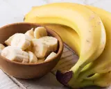 Banan wartości odżywcze: pyszne, żółte banany obok miseczki z pokrojonymi plasterkami. Idealne na zdrową przekąskę.