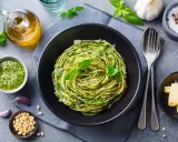 Pyszne spaghetti z pesto to idealna odpowiedź na pytanie: co zrobić na obiad bezmięsny. Podane z parmezanem i świeżą bazylią.