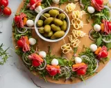 Kolorowe przekąski na urodziny: szaszłyki z pomidorkami, mozzarellą, salami i marchewką, oliwki i serowe zawijasy.