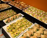 Nowoczesne potrawy wielkanocne: kolorowe kanapki, tosty i croissanty z serem, wędliną i warzywami tworzą apetyczny bufet.