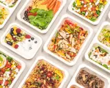 Catering dietetyczny co to? Różnorodne, zdrowe posiłki w wygodnych pojemnikach: sałatki, dania z kurczakiem, kaszą, owocami i warzywami.