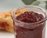 Słoiczek z konfiturą z płatków róży obok ciastka.