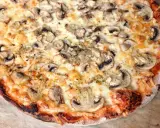 Pyszna pizza capricciosa z pieczarkami i ciągnącym się serem, idealna na szybki obiad.