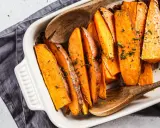 Pieczone bataty w naczyniu, posypane ziołami. Idealne, by pomyśleć co do batatów na obiad.