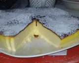 Puszysty sernik z airfryer, oprószony cukrem pudrem, z lekko przypieczoną skórką i kremowym wnętrzem.