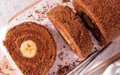 Czekoladowa, najprostsza rolada biszkoptowa z bananem w środku, posypana wiórkami. Idealna na deser.