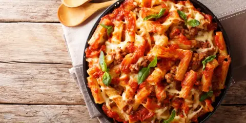 Pyszne danie z makaronem rigatoni, sosem pomidorowym i mięsem mielonym, zapieczone z serem. Idealne co na obiad z mięsa mielonego.
