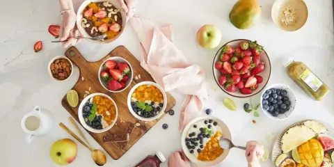 Zdrowe śniadanie w stylu self-catering: owsianka z owocami, jagodami, mango i orzechami. Idealne na początek dnia.