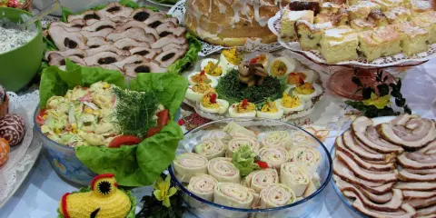 Mnóstwo pyszności na stole, idealnych na to, co ugotować na święta: pieczone mięsa, sałatki, jajka faszerowane, babka i ciasta.