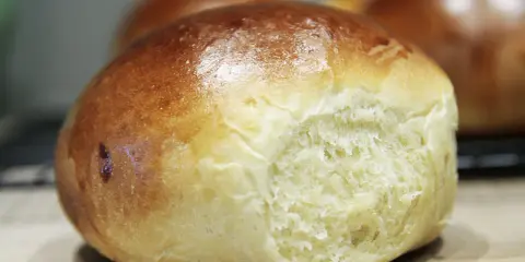 Złociste bułeczki brioche z widocznym, puszystym wnętrzem.