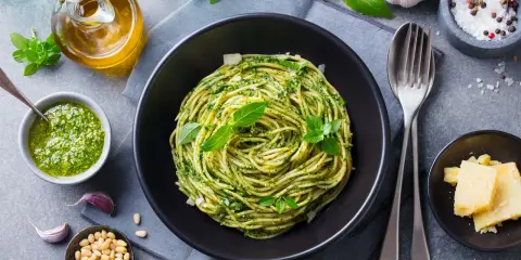 Pyszne spaghetti z pesto to idealna odpowiedź na pytanie: co zrobić na obiad bezmięsny. Podane z parmezanem i świeżą bazylią.
