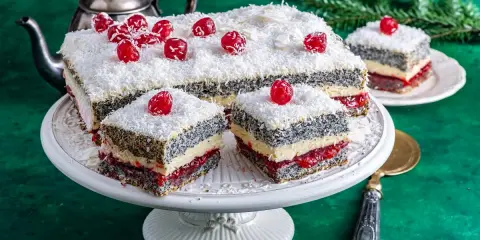 Pyszna makowa panienka z wiśniami i wiórkami kokosowymi, podana na paterze.