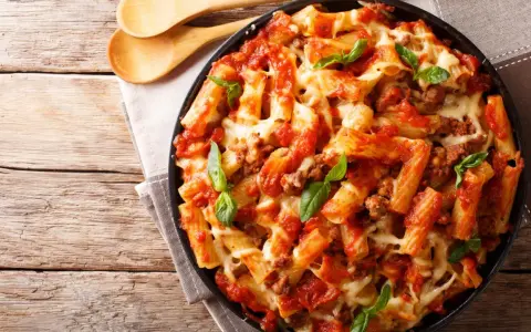 Pyszne danie z makaronem rigatoni, sosem pomidorowym i mięsem mielonym, zapieczone z serem. Idealne co na obiad z mięsa mielonego.