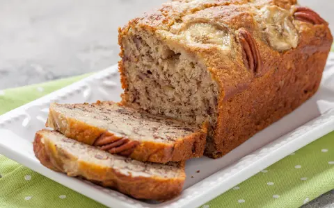 Chlebek bananowy Ani gotuje się wspaniale, z orzechami pekan i plasterkami banana na wierzchu.