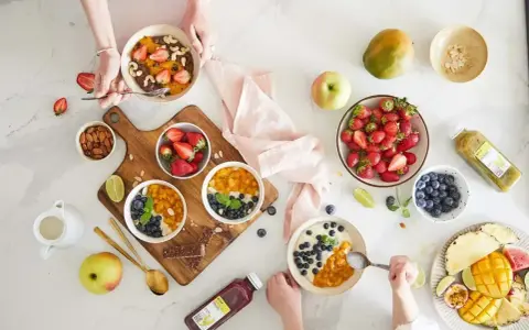 Zdrowe śniadanie w stylu self-catering: owsianka z owocami, jagodami, mango i orzechami. Idealne na początek dnia.