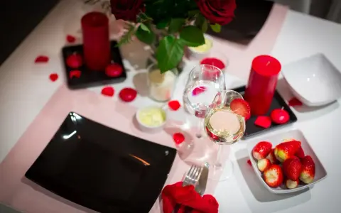 Romantyczna kolacja walentynkowa: czerwone róże, świece, wino i truskawki. Idealne inspiracje, co ugotować na walentynki.