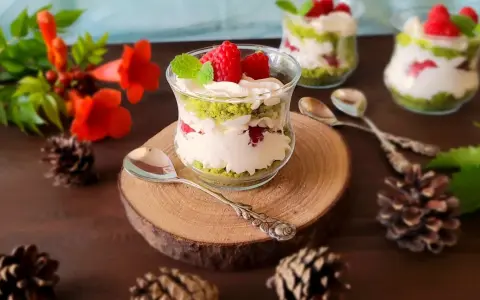 Pyszne ciasto leśny mech na dużą blachę z serkiem mascarpone, podane w szklanych pucharkach, ozdobione malinami i miętą.