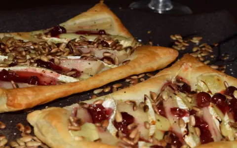 Ciasto francuskie z camembertem, gruszką i żurawiną, posypane słonecznikiem.