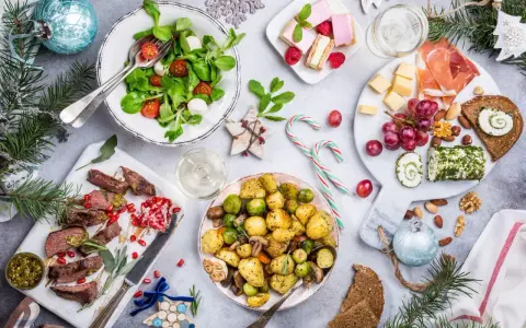 Wigilia na talerzu: pieczone ziemniaki, mięso, sałatka, ser, słodkości. Zastanawiasz się, ile kosztuje catering na wigilię?