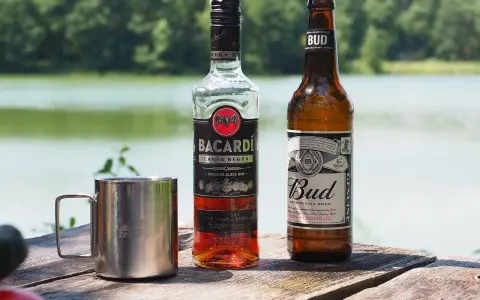 Bacardi Carta Negra i piwo Bud na drewnianym stole. Zastanawiasz się, jaki alkohol do tiramisu? Rum Bacardi to świetny wybór!