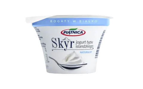 Opakowanie jogurtu typu islandzkiego Skyr Piątnica Naturalny z łyżką pełną jogurtu.