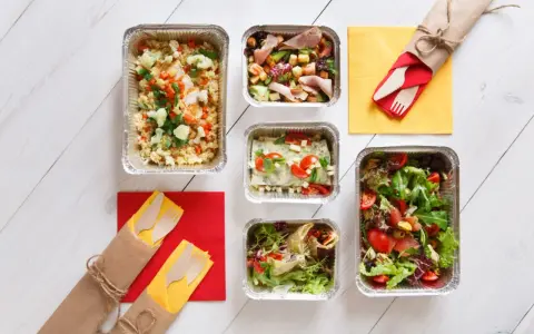 Różnorodne dania w pojemnikach, sałatki, wrap, zapiekanka i ryż z warzywami. Zastanawiasz się, ile kosztuje catering na 20 osób?