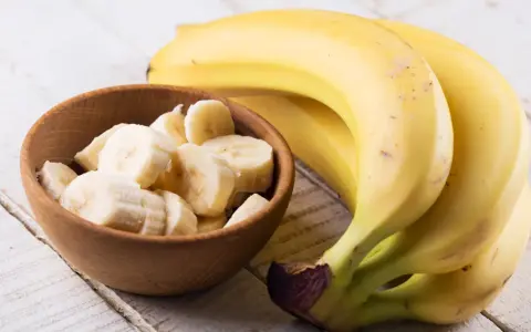 Banan wartości odżywcze: pyszne, żółte banany obok miseczki z pokrojonymi plasterkami. Idealne na zdrową przekąskę.
